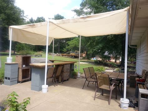 With scissors, trim the 6-inch x 6-inch squares from the corners of the canvas, then turn a 14-inch hem on all edges of the canvas. . How to make a cheap outdoor canopy